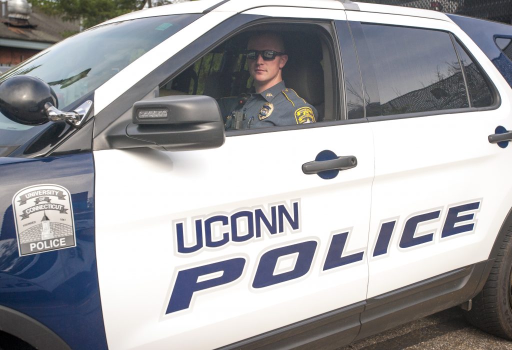 UConn Police Officer with his patrol car on June 16, 2016. (Sean Flynn/UConn Photo)