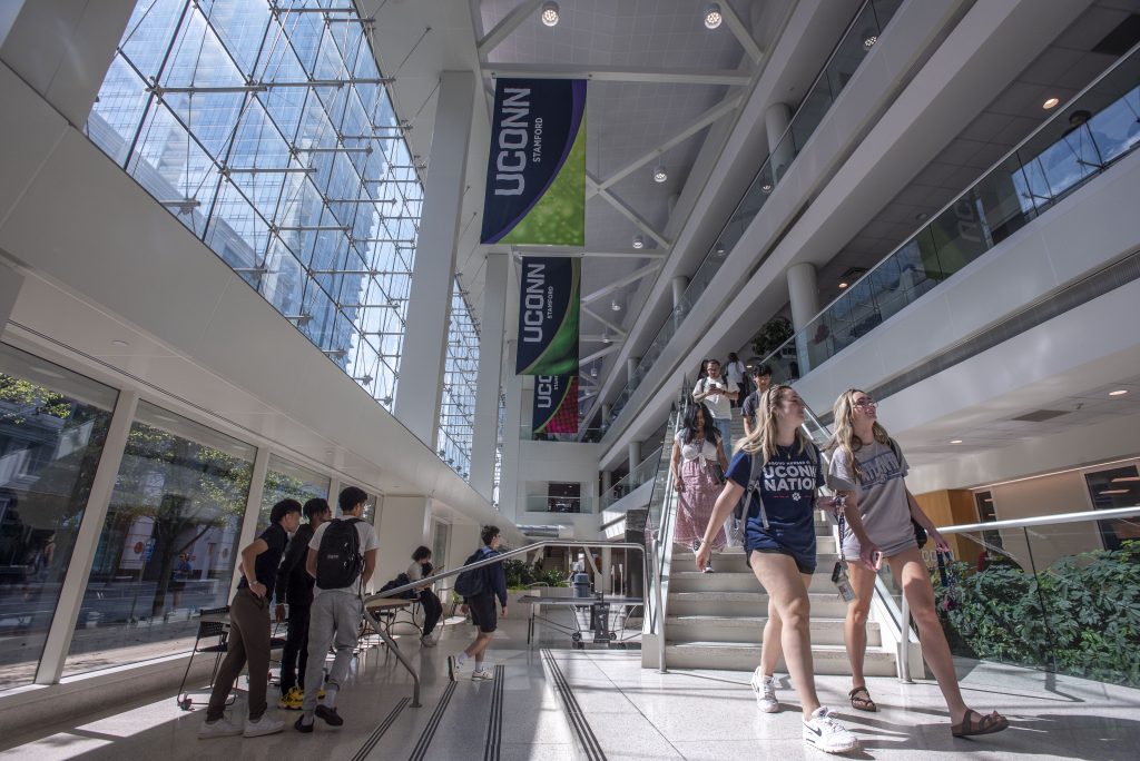 Students walking down the stairs in the courtyard (atrium) UConn Stamford on Sept. 19, 2024. (Sean Flynn/UConn Photo)