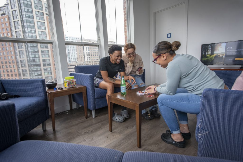 UConn Stamford students in their apartment playing a card game, UNO. April 6, 2022. (Sean Flynn)