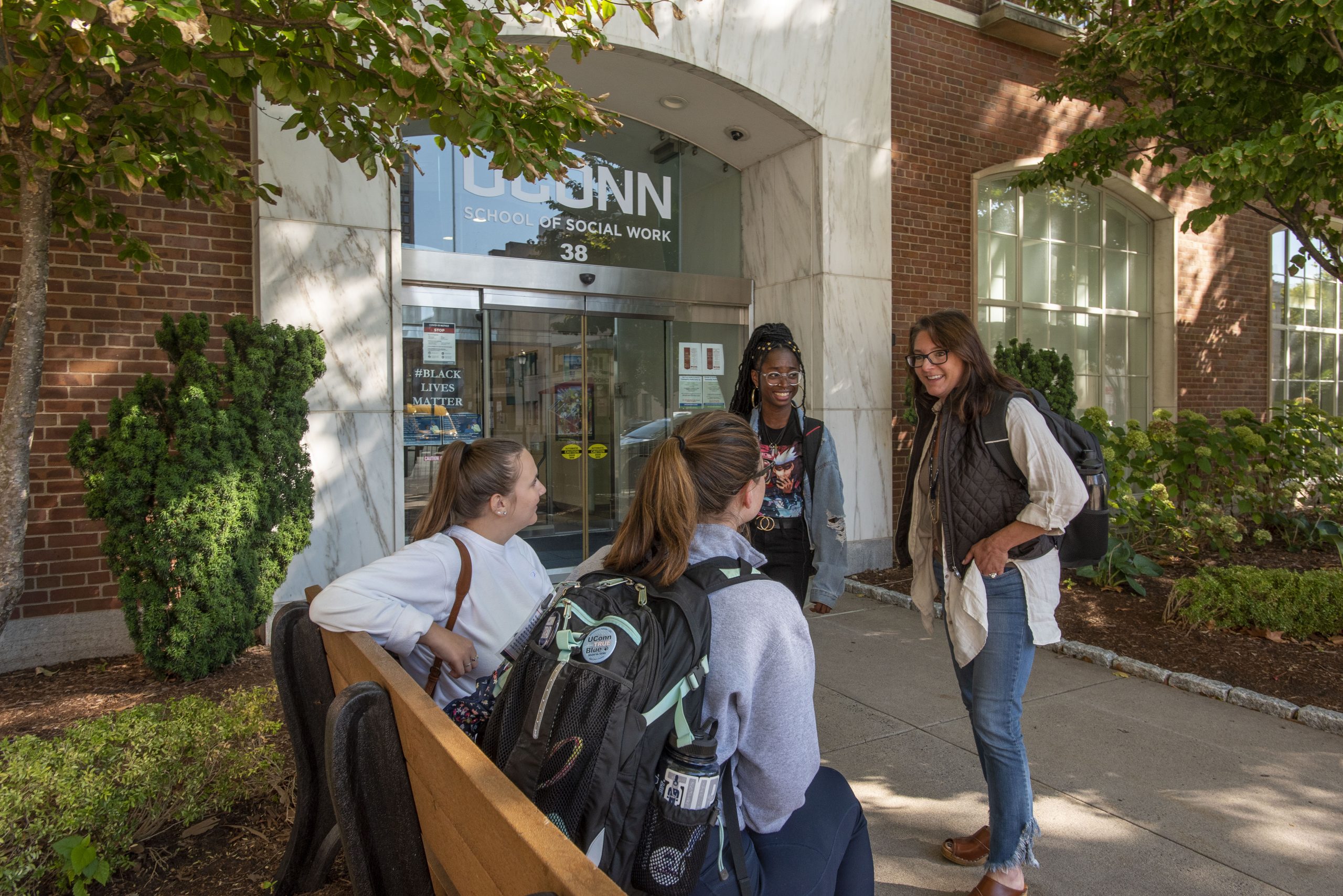 A group of master’s students talking outside the School of Social Work (SSW) building.  Sept. 15, 2022. (Sean Flynn/UConn Photo)