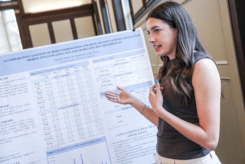 Woman presenting her honors research poster board