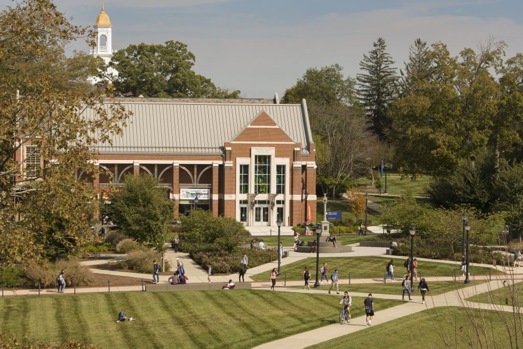 Students walking across campus in front of the Benton Museum and the Student Union Mall