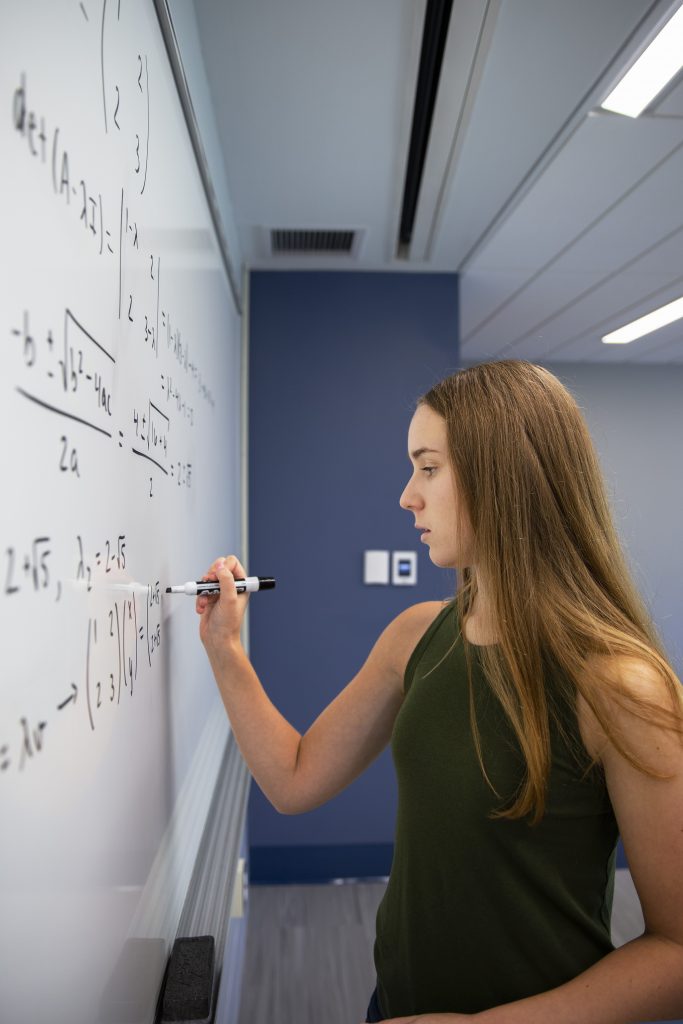 a mathematics and cognitive science major works on a math problem in the Monteith Building