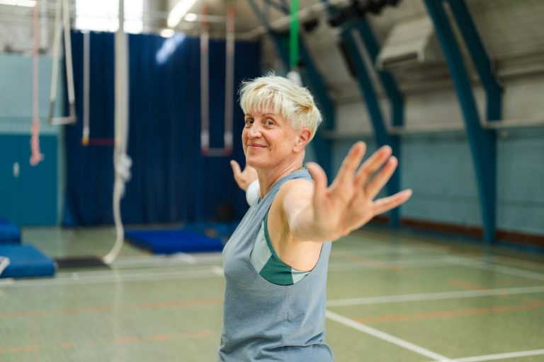 Older woman stretching in gym