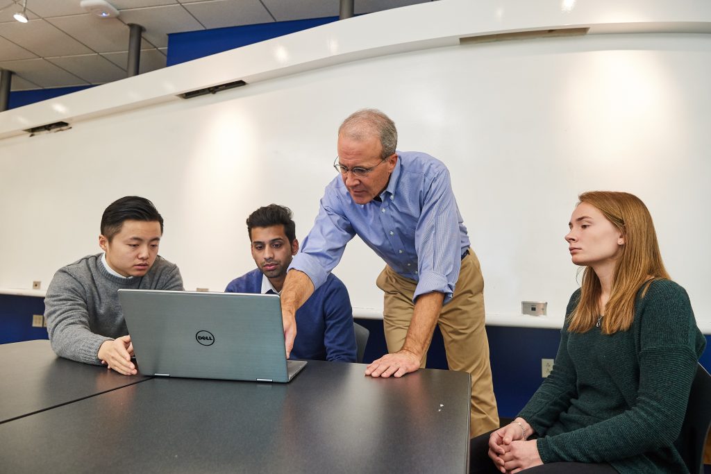 Blake Mather, an adjunct faculty member, meets with student managed fund members