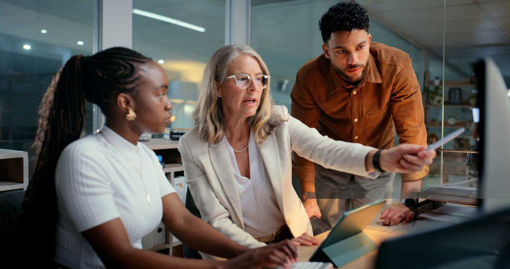 Mentor is training employees in office to prepare accounting reports and to track financial payments or budget review.