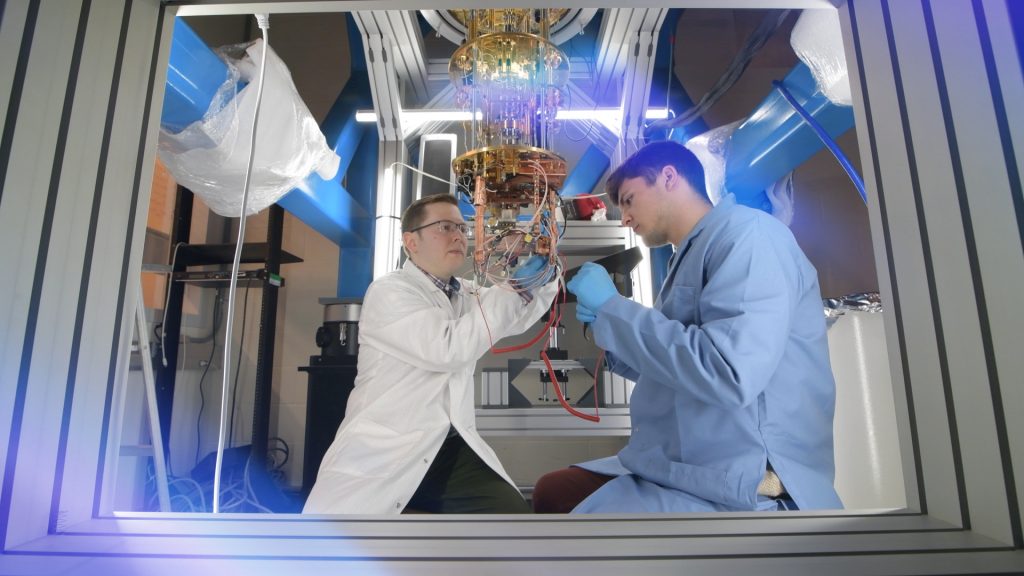 Two researchers working on wiring on a quantum computer